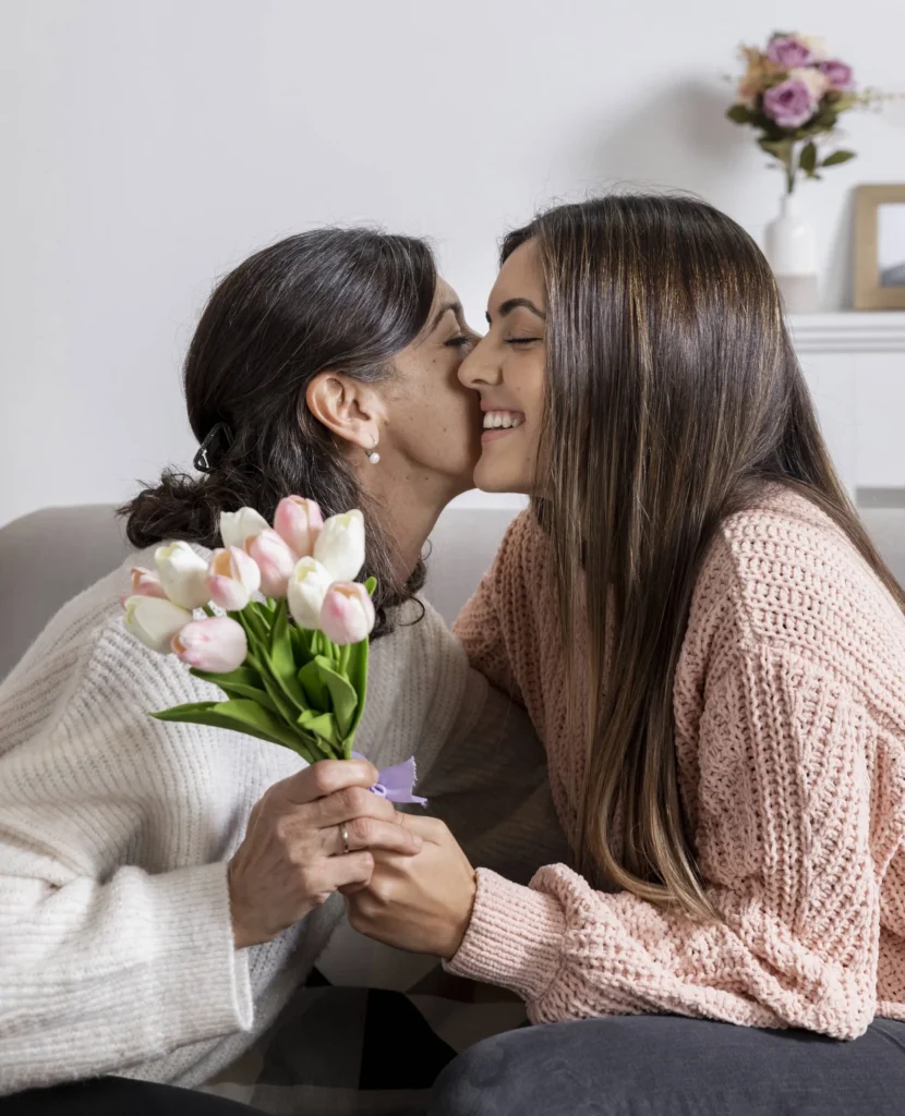 side view girl offering flowers mom