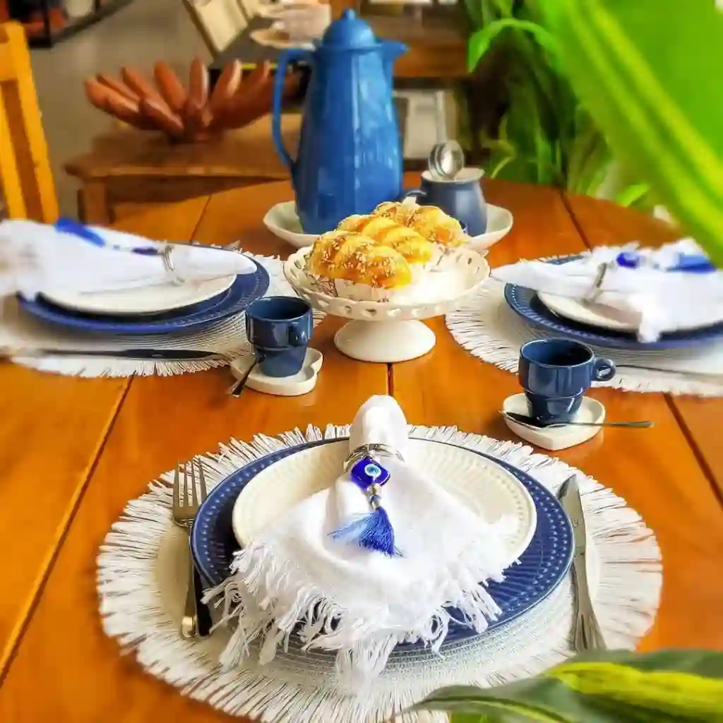Mesa posta com pratos e iguarias decorativas.