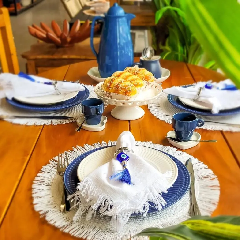 Mesa posta com pratos e iguarias decorativas.