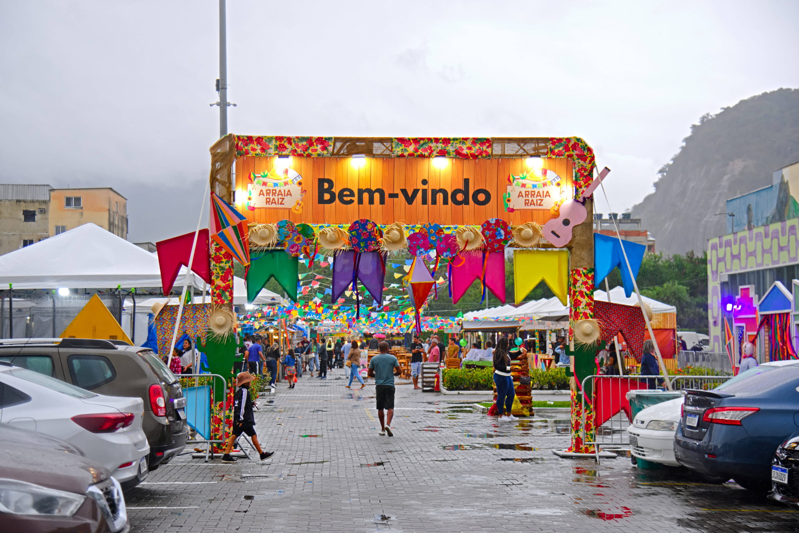 Entrada do Arraial com decoração colorida e pessoas