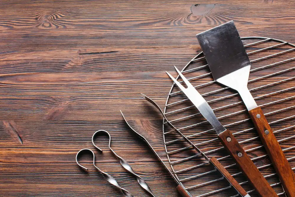 Conjunto de ferramentas de churrasco sobre uma grelha