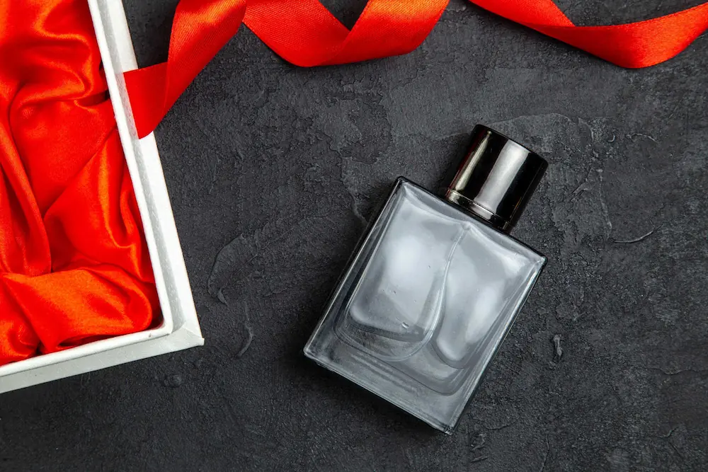 Frasco de perfume elegante com laço vermelho