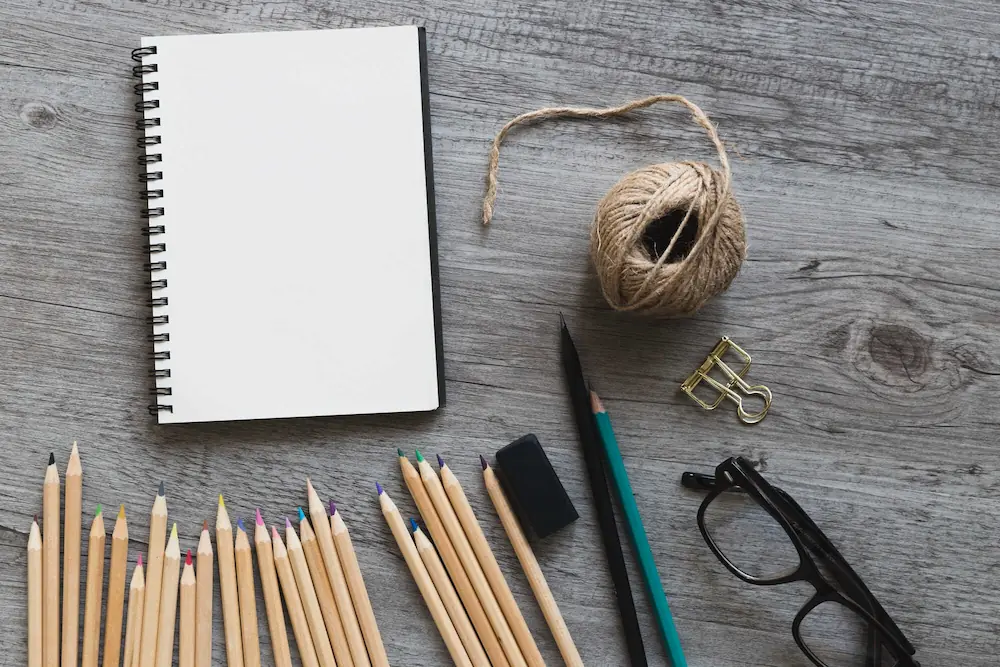 Material de desenho com lápis, caderno e fio de sisal