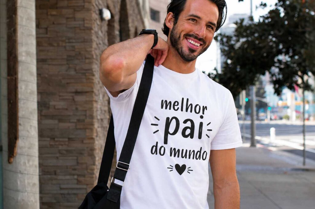 Homem sorridente com camiseta 'melhor pai do mundo'.