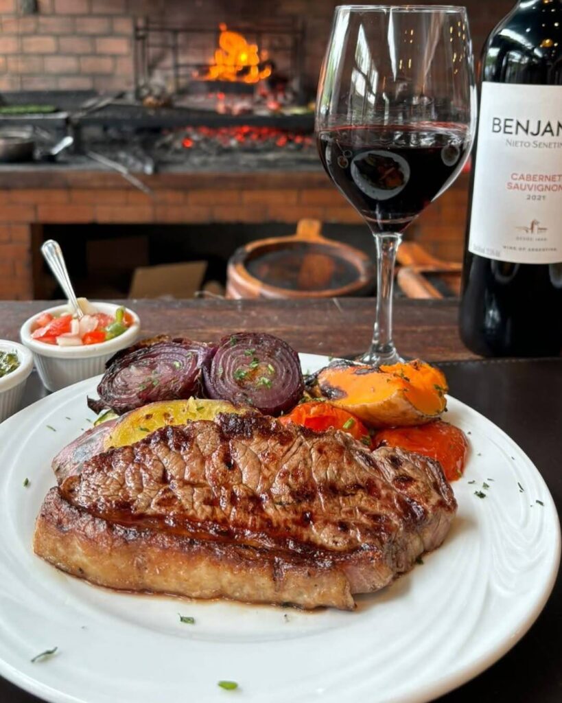 Prato de carne grelhada com legumes e vinho tinto