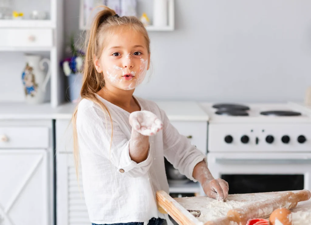 Menina fazendo receitas na cozinha com farinha