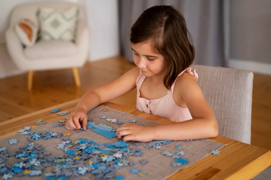 986 garota brincando com brinquedos de quebra cabeca Menina feliz montando um quebra cabeças