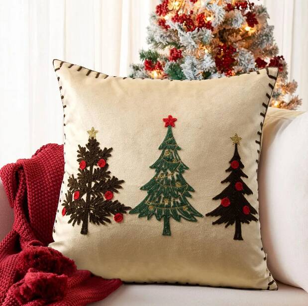 Almofada decorativa de Natal com árvore e estrelas.