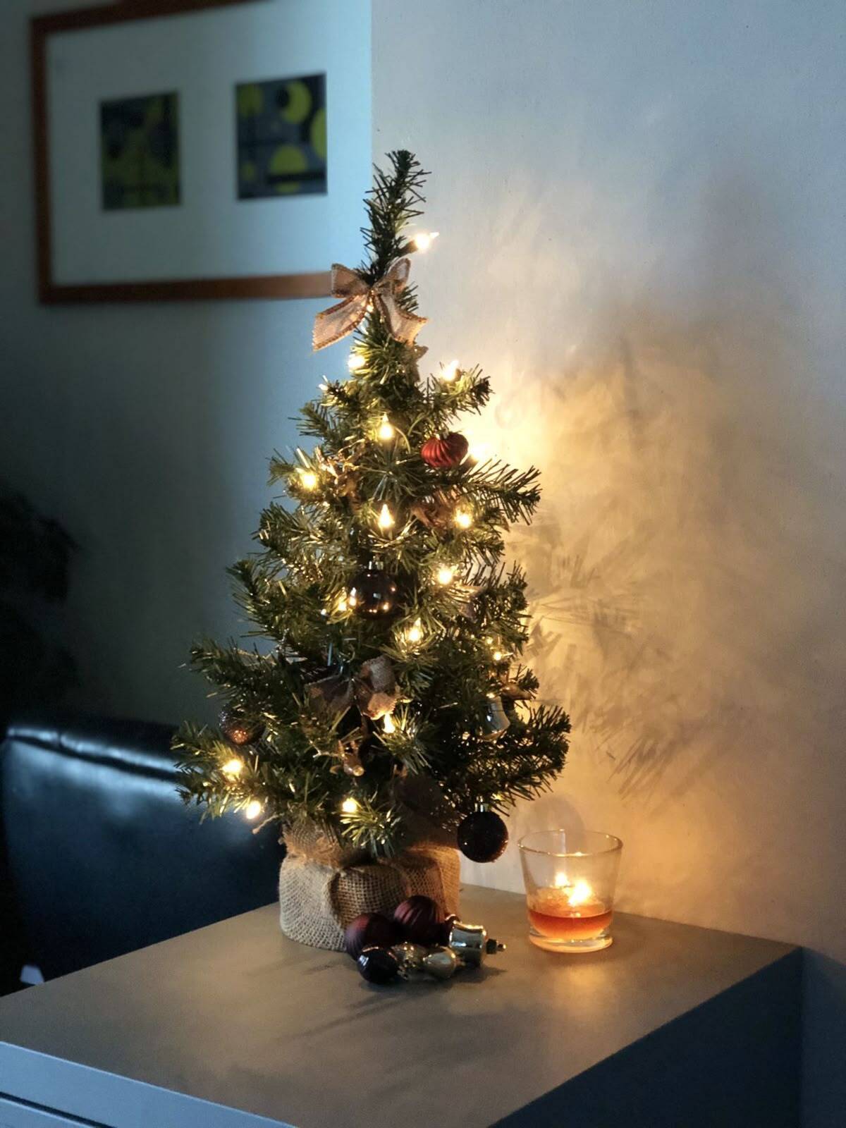 Mini árvore de Natal decorada com luzes e velas.