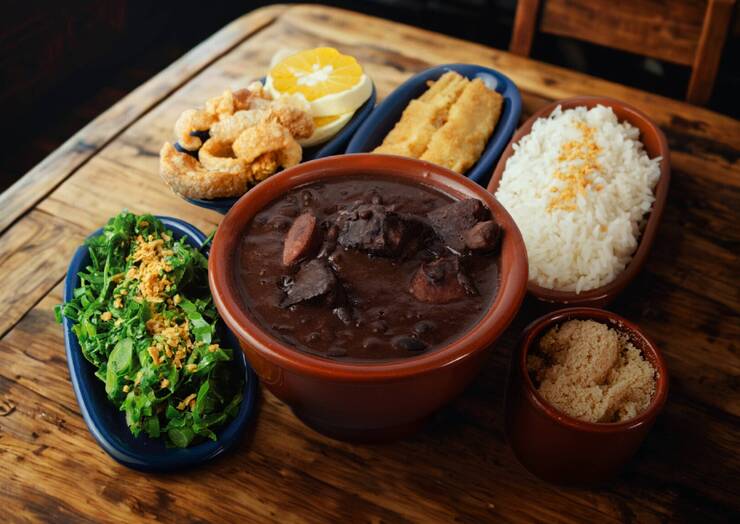 Feijoada acompanhada de arroz, farofa e legumes frescos