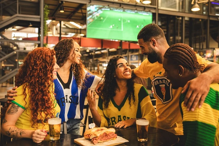 Amigos se divertindo em bar durante jogo da seleção brasileira.