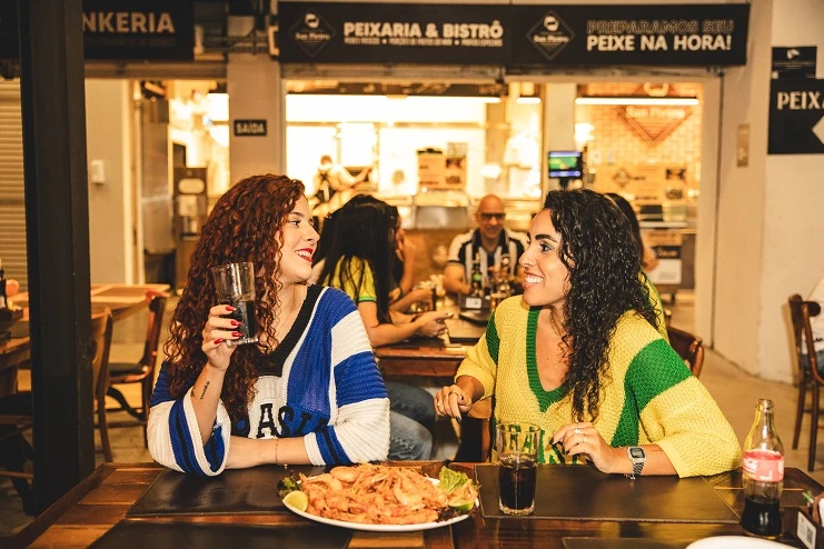Duas mulheres conversando em restaurante descontraído