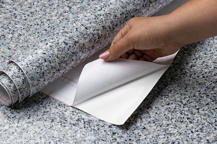 8ceb2c71 still life putting up decorative vinyls 23 2149683453 Pessoa descolando papel adesivo para revestimento.