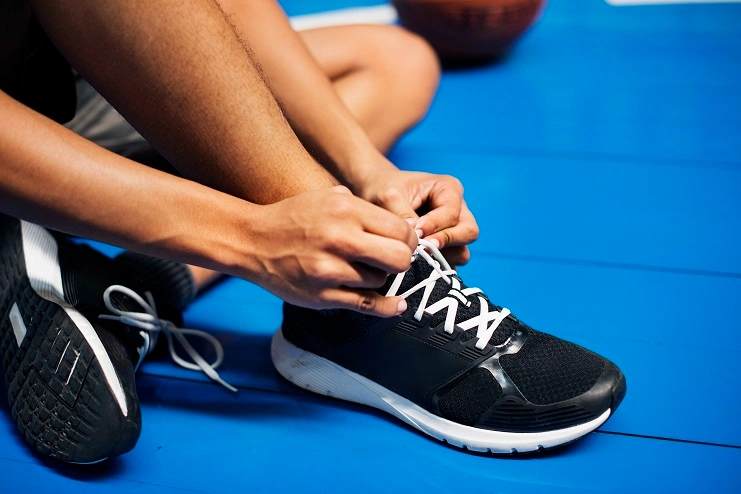 9260f255 african american teenage boy tying his shoe laces basketball court Pessoa amarrando o tênis em uma quadra de esportes