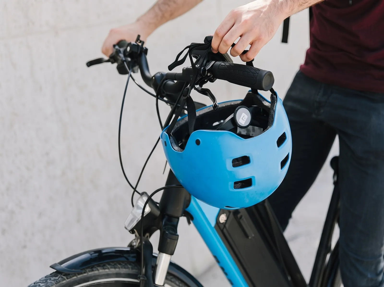 Ciclista segurando bicicleta com capacete azul.