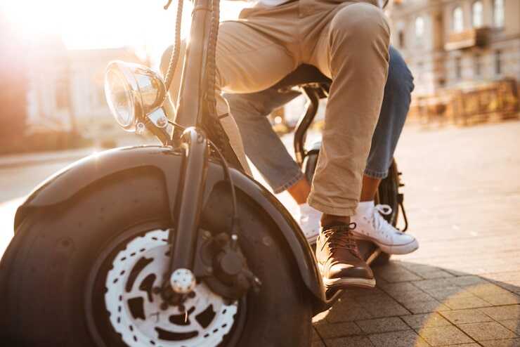 Pessoa em scooter elétrica ao pôr do sol.