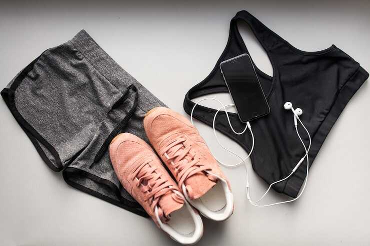 Roupas de ginástica e tênis em cima da mesa.