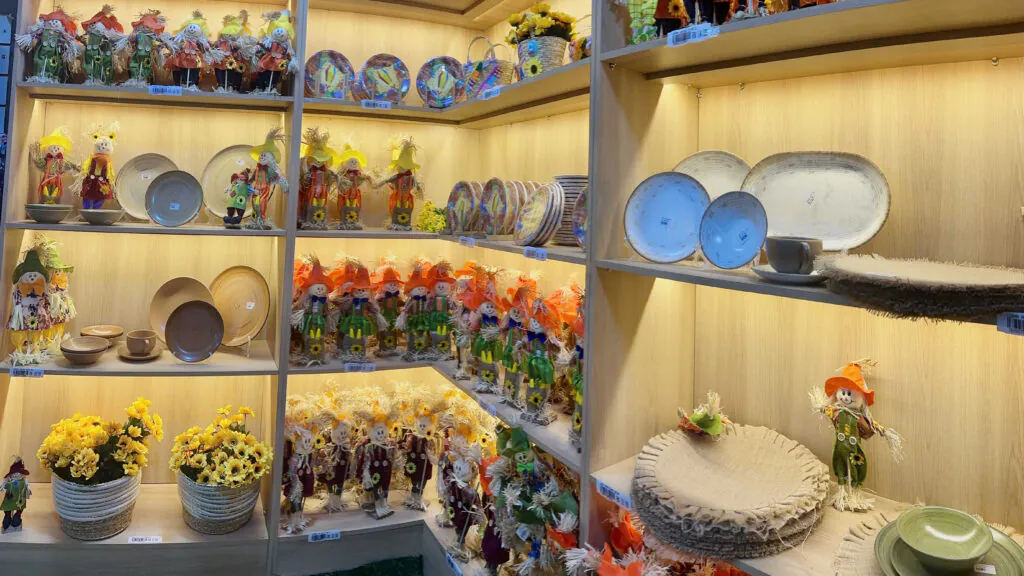 Prateleira com artesanato colorido e decoração em cerâmica.